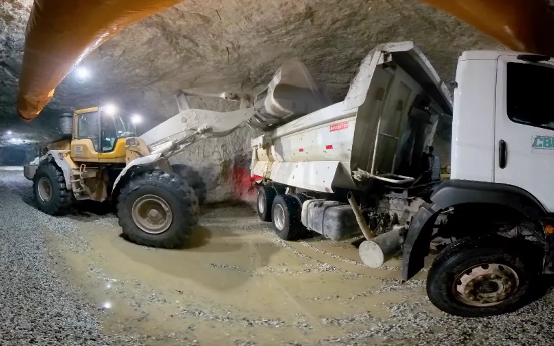 Caminhão e pá carregadeira dentro da mina de lítio da CBL