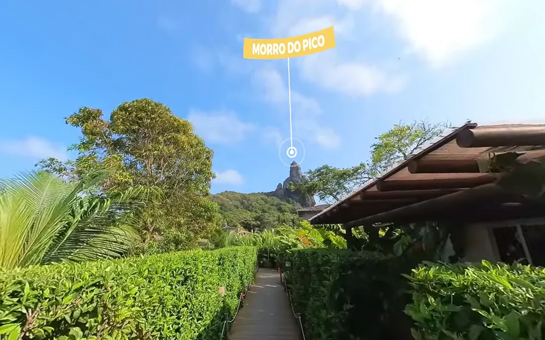 Caminho entre jardins do hotel com o Morro do Pico ao fundo