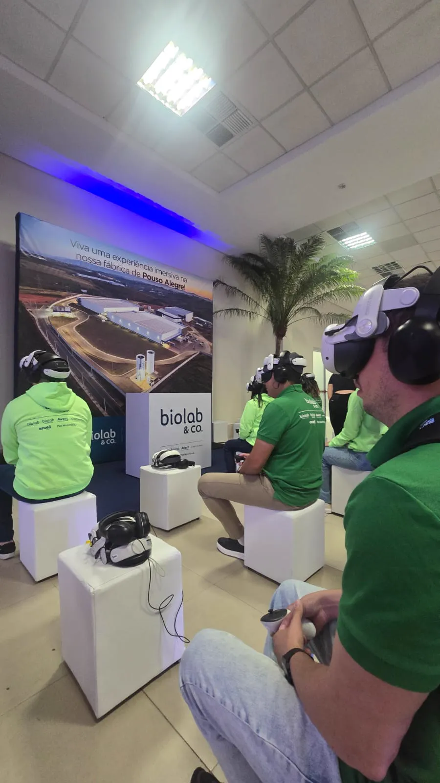 Colaboradores sentados em pufes usando óculos VR
